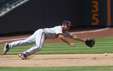 FILE PHOTO - Washington Nationals third baseman Alex Cora dives for a base hit by New York Mets batter Jason Bay in the second inning of their MLB National League baseball game in New York, May 19, 2011. REUTERS/Ray Stubblebine