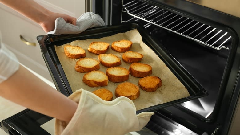 pulling pan of toast from oven