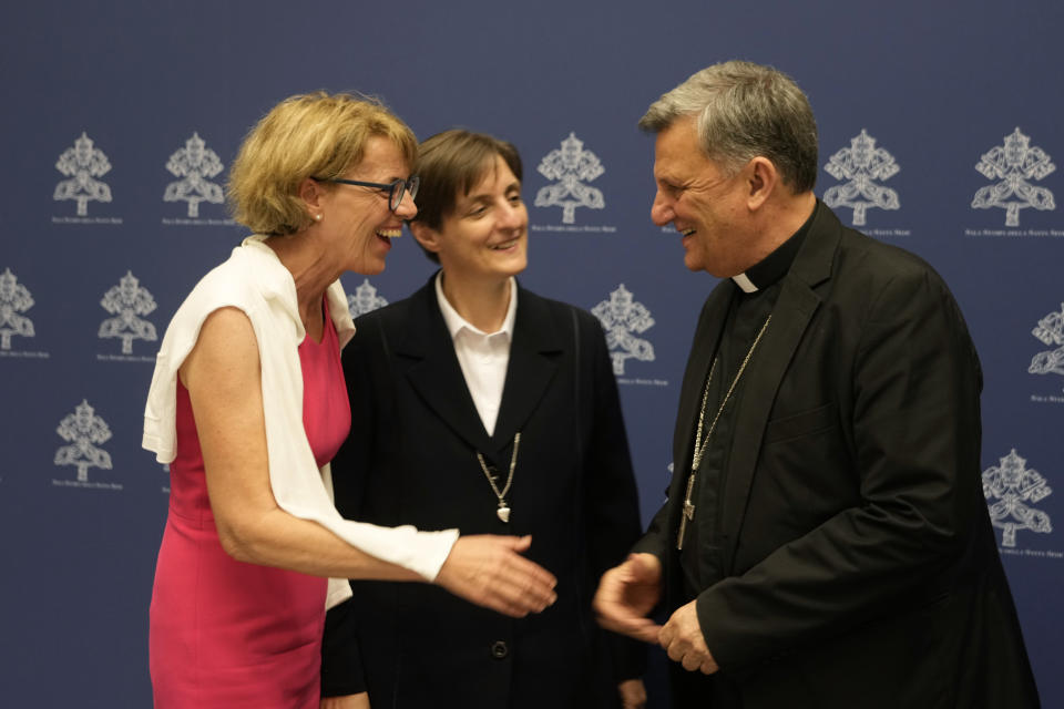 Helena Jeppesen Spuhler, left, smiles with Secretary General of the Synod of Bishops Cardinal Mario Grech, right, and Sister Nadia Coppa at the end of a presentation of the new guidelines for the Synod of Bishops at the Vatican, Tuesday, June 20, 2023. (AP Photo/Domenico Stinellis)