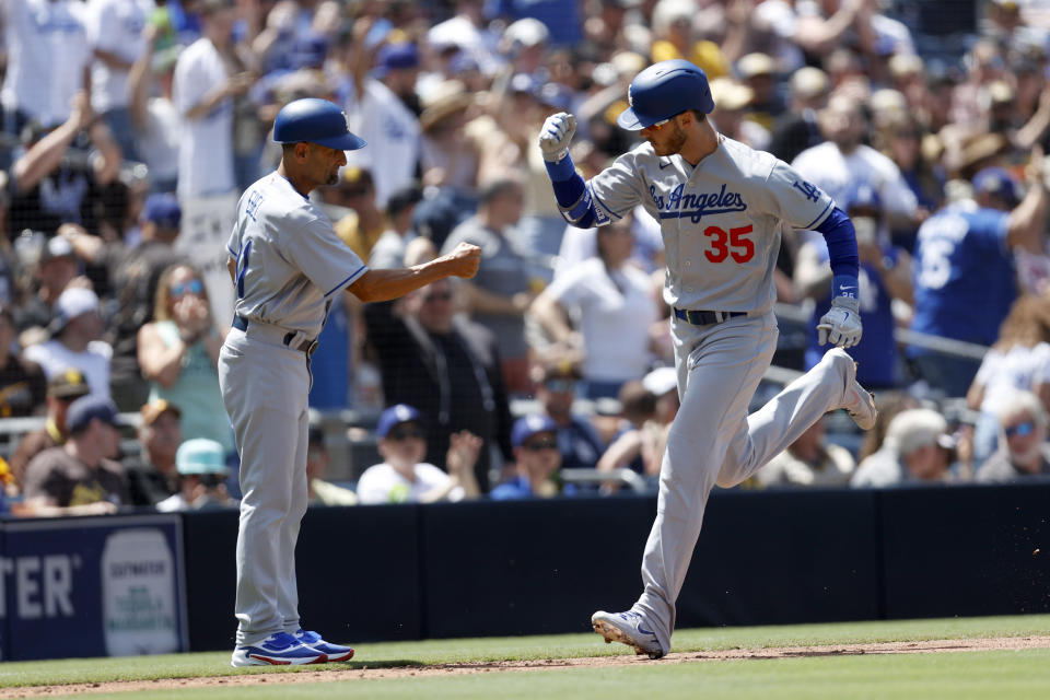 Los Angeles Dodgers' Cody Bellinger (35) celebrates with third base coach Dino Ebel after hitting a solo home run against the San Diego Padres during the fourth inning of a baseball game Sunday, April 24, 2022, in San Diego. (AP Photo/Mike McGinnis)