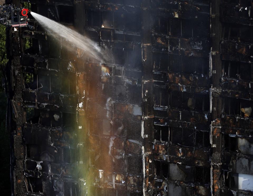 <p>The sun creates a rainbow effect as firefighters work at the scene of a deadly blaze at a high rise apartment block in London, Wednesday, June 14, 2017. (Photo: Alastair Grant/AP) </p>
