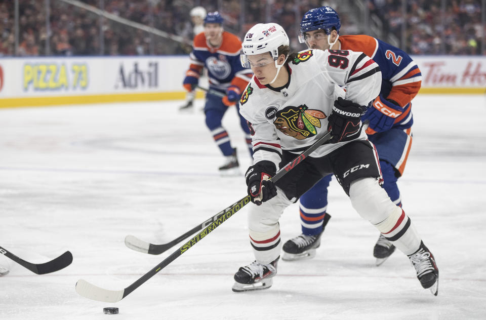 Chicago Blackhawks' Connor Bedard is chased by Edmonton Oilers' Evan Bouchard (2) during the first period of an NHL hockey game in Edmonton, Alberta, on Tuesday Dec. 12, 2023. (Jason Franson/The Canadian Press via AP)