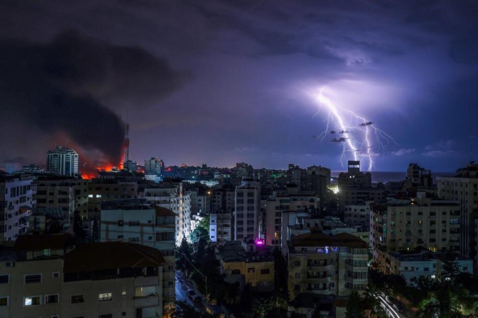 Lightning strikes as smoke billows following an Israeli airstrike in Gaza City on Oct. 9.<span class="copyright">Mohammed Abed/AFP/Getty Images</span>