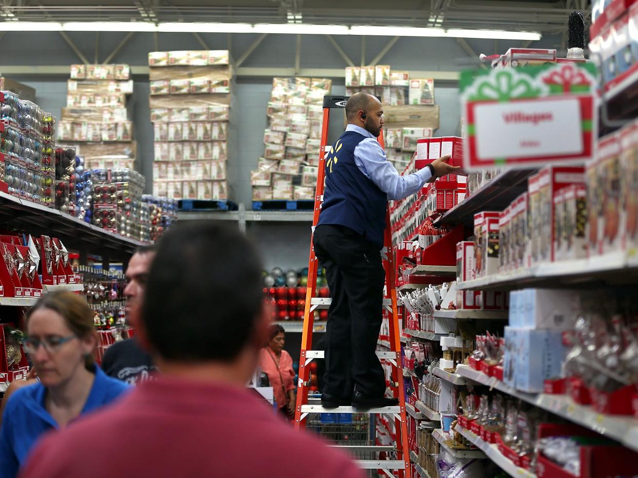 Walmart worker stands on ladder in store during holiday shopping season