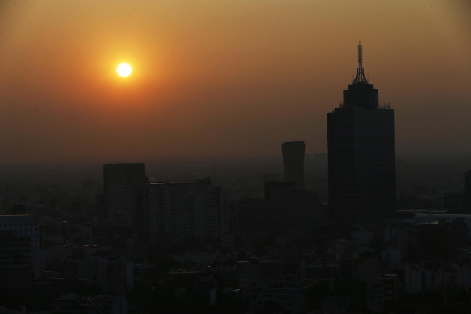 The sun rises amid smog in Mexico City, Friday, May 8, 2020. The previous day, Mexico saw its largest one-day increase yet in confirmed cases of COVID-19. (AP Photo/Marco Ugarte)
