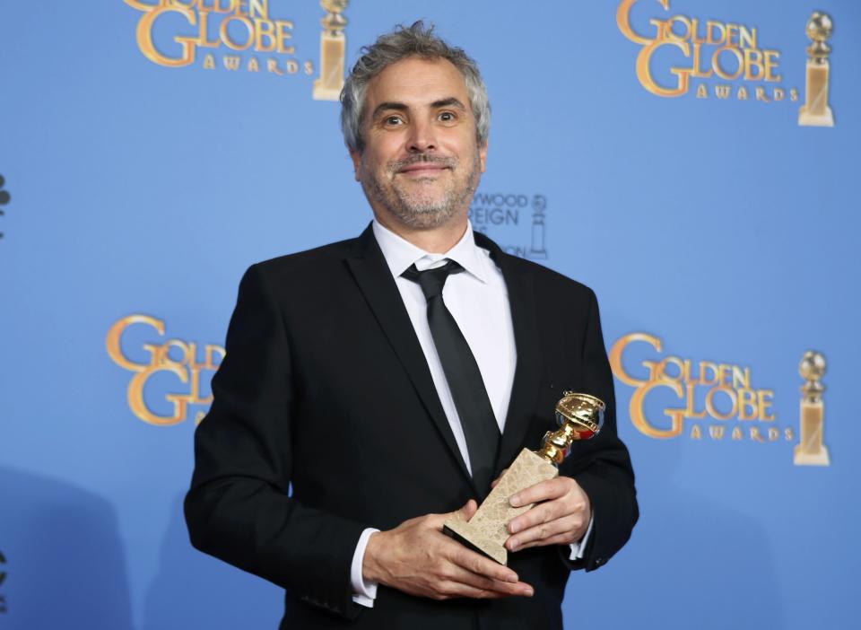 Director Alfonso Cuaron poses backstage with his Best Director Motion Picture award for "Gravity" at the 71st annual Golden Globe Awards in Beverly Hills