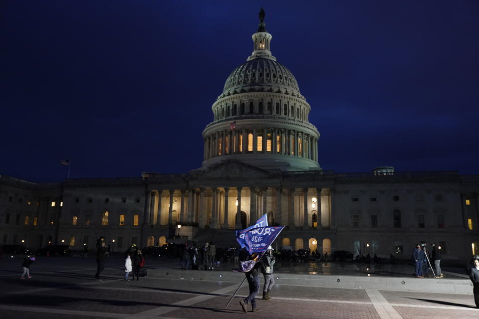 Un partidario del presidente Donald Trump sostiene una bandera en favor del mandatario afuera del Capitolio, en Washington, el miércoles 6 de enero de 2021. (AP Foto/Jacquelyn Martin)