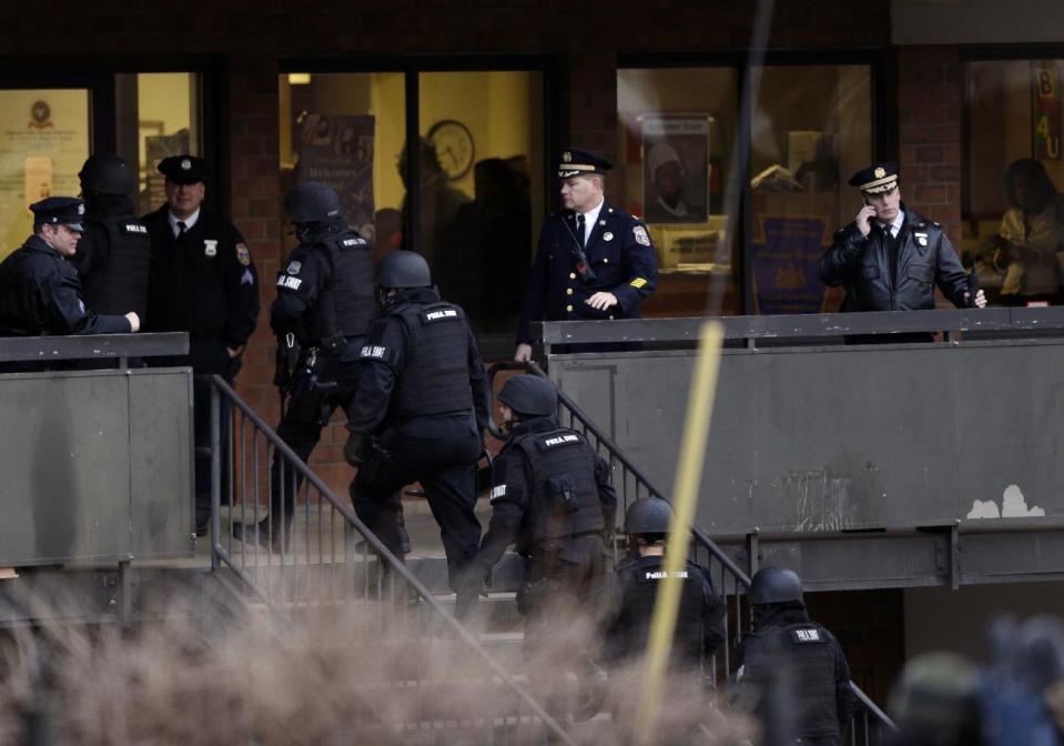 Police enter the Delaware Valley Charter School Friday, Jan. 17, 2014, in Philadelphia. Police say two students have been shot at a Philadelphia high school. (AP Photo/Matt Rourke)