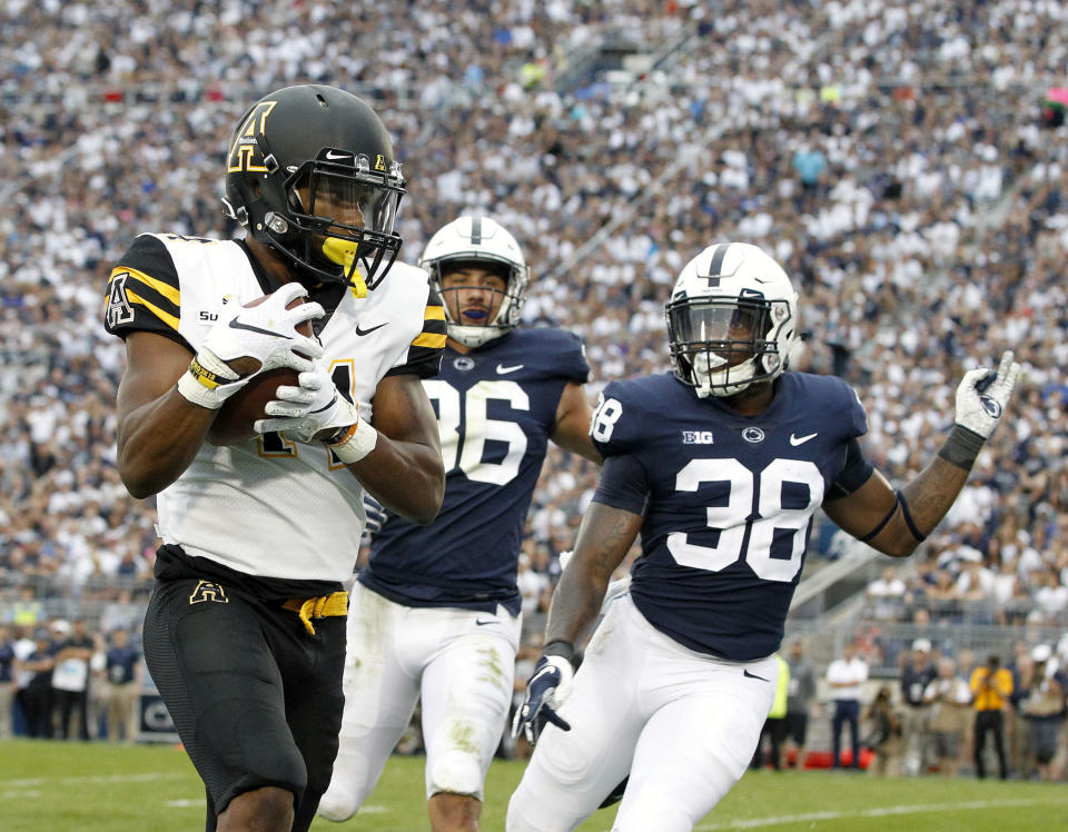 Appalachian State's Malik Williams (14) hauls in touchdown as Penn State's Lamont Wade (38) and Jan Johnson (36) give chase during the second half of an NCAA college football game in State College, Pa., Saturday, Sept. 1, 2018. Penn State won 45-38 in OT. (AP Photo/Chris Knight)