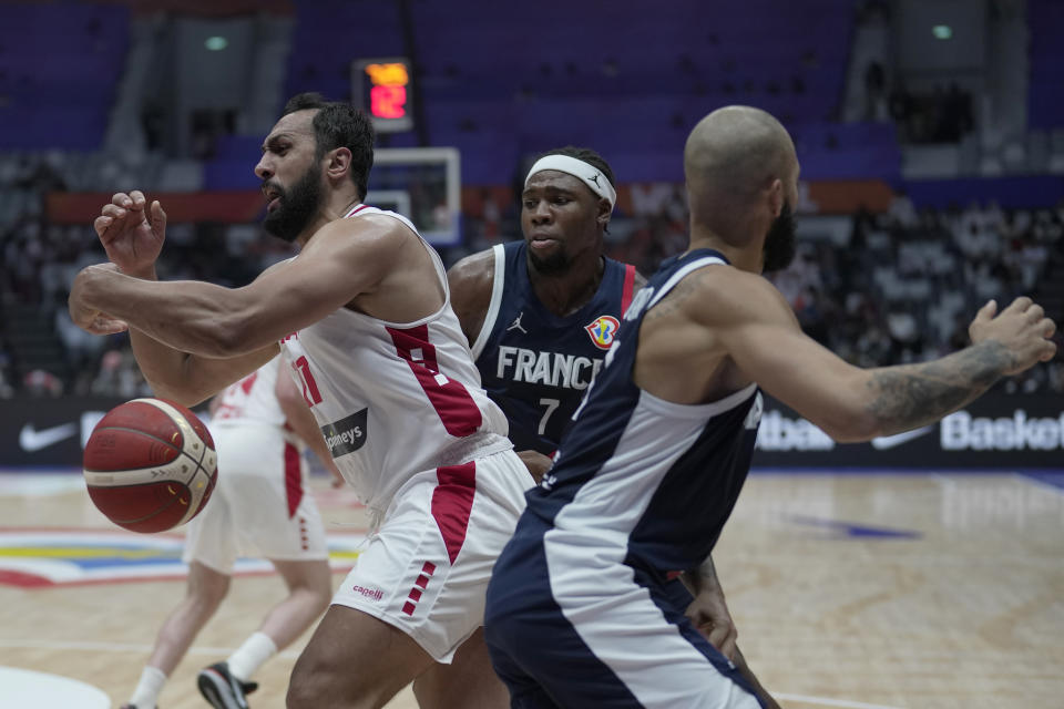 Lebanon forward Ali Haidar (11) drives against France forward Guerschon Yabusele (7) and guard Evan Fournier (10) during the Basketball World Cup group H match between France and Lebanon at the Indonesia Arena stadium in Jakarta, Indonesia, Tuesday, Aug. 29, 2023. (AP Photo/Dita Alangkara)