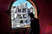 <p>A member of the Syrian Democratic Forces (SDF), backed by US special forces, looks out from a building at the frontline in Raqa on Oct. 16, 2017 in the Islamic State (IS) group jihadist’ crumbling stronghold. (Photo: Bulent Kilic/AFP/Getty Images) </p>