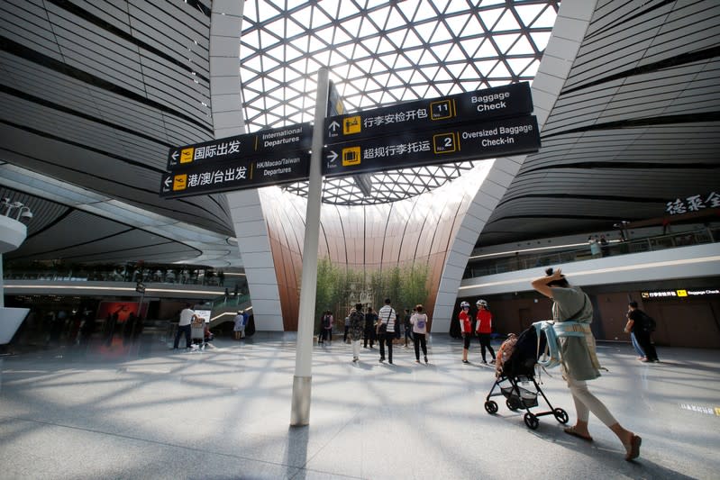 People walk at the terminal hall of the newly launched Daxing International Airport on the outskirts of Beijing