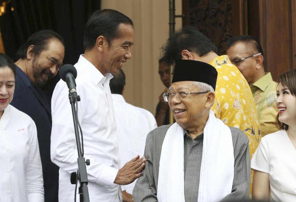 Incumbent Indonesian President Joko Widodo, center left, shares a light moment with his running mate Ma'ruf Amin, center right, during a press conference after a meeting with their coalition parties in Jakarta, Indonesia,, Thursday, April 18, 2019. Widodo said Thursday he was won reelection after securing an estimated 54% of the vote, backtracking on an earlier vow to wait for official results after his challenger made improbable claims of victory. (AP Photo/Achmad Ibrahim)