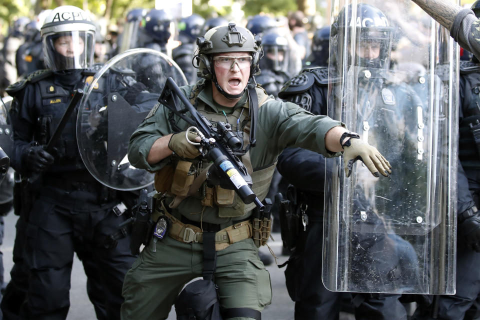 Police begin to clear demonstrators gathered as they protest the death of George Floyd, Monday, June 1, 2020, near the White House in Washington. Floyd died after being restrained by Minneapolis police officers. (AP Photo/Alex Brandon)