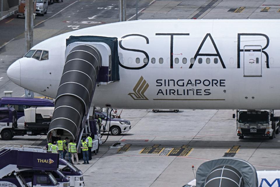 Officials enter the Singapore Airlines Boeing 777-300ER airplane that made an emergency landing in Bangkok due to severe turbulence (AFP via Getty Images)