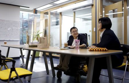 Kim So-young, a former gymnast who was paralysed from the neck down at 16 after falling off the parallel bars while training, smiles as she talks to former Olympic gold medalist Jang Mi-ran (R) at her office in Seoul, South Korea, October 23, 2015. REUTERS/Kim Hong-Ji