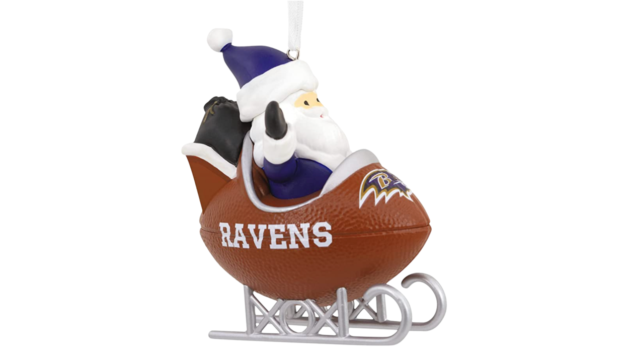 Santa in football sled with Ravens logo in front.