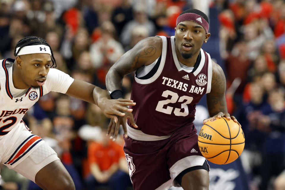 Texas A&M guard Tyrece Radford (23) dribbles around Auburn guard Denver Jones (12) as he goes to the basket during the first half of an NCAA college basketball game Tuesday, Jan. 9, 2024, in Auburn, Ala. (AP Photo/Butch Dill)