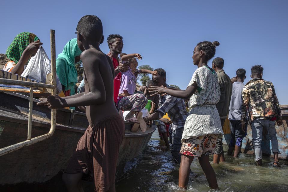 Tigray refugees who fled the conflict in the Ethiopia's Tigray arrive on the banks of the Tekeze River on the Sudan-Ethiopia border, in Hamdayet, eastern Sudan, Tuesday, Dec. 1, 2020. (AP Photo/Nariman El-Mofty)