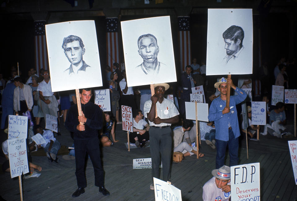 <p>Members of the Mississippi Freedom Democratic Party stand and hold up sketches of three slain civil rights volunteers (from left, Andrew Goodman, James Chaney, and Michael Schwerner) during a demonstration outside the Democratic National Convention, Atlantic City, New Jersey, August 1964. (Photo: Ralph Crane/The LIFE Picture Collection/Getty Images) </p>