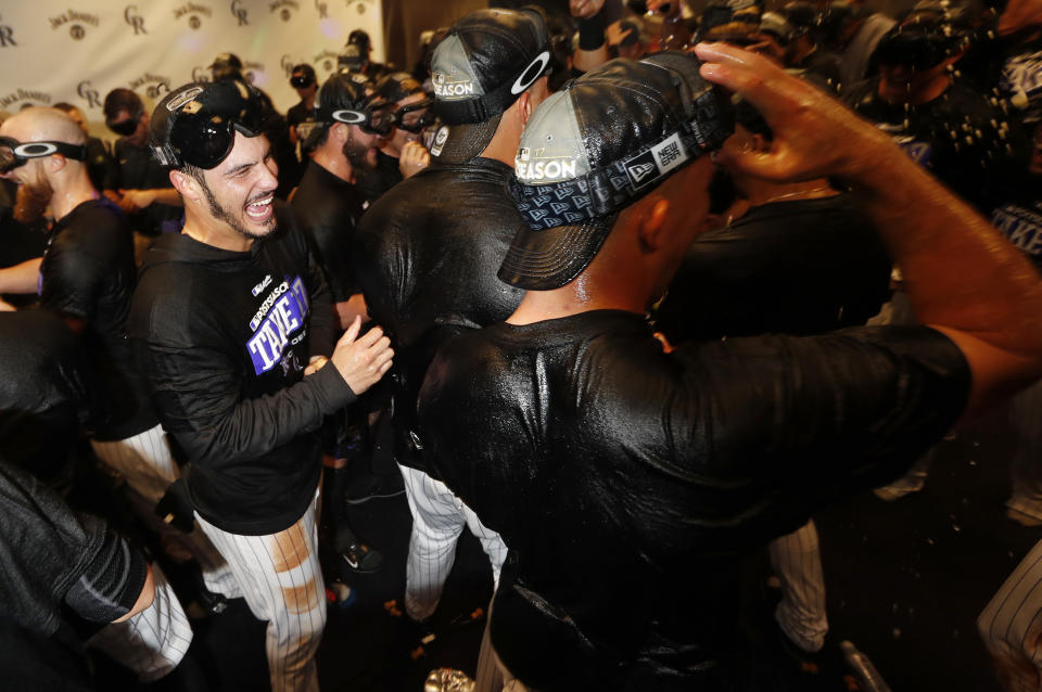 Rockies third baseman Nolan Arenado (left) celebrates with teammates after securing a National League Wild Card berth on Saturday. (AP)