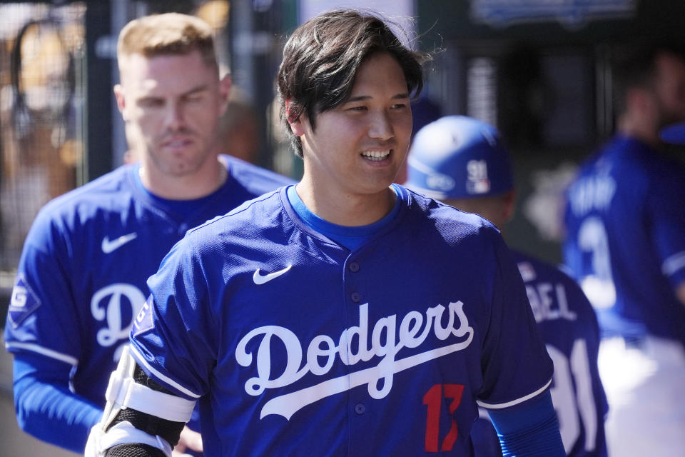 FILE - Los Angeles Dodgers' Shohei Ohtani, of Japan, walks through the dugout during the team's spring training baseball game against the Seattle Mariner, March 13, 2024, in Phoenix. Beginning with its ninth international opener, Major League Baseball is traveling all over the world in 2024. Ohtani and the Dodgers play Manny Machado and the San Diego Padres in Seoul, South Korea (AP Photo/Ross D. Franklin, File)