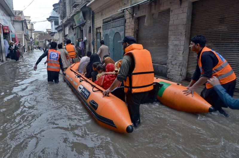 Volunteers from the Alkhidmat Foundation assist people after torrential rain, thunderstorms, and lightning caused havoc nationwide. -/PPI via ZUMA Press Wire/dpa