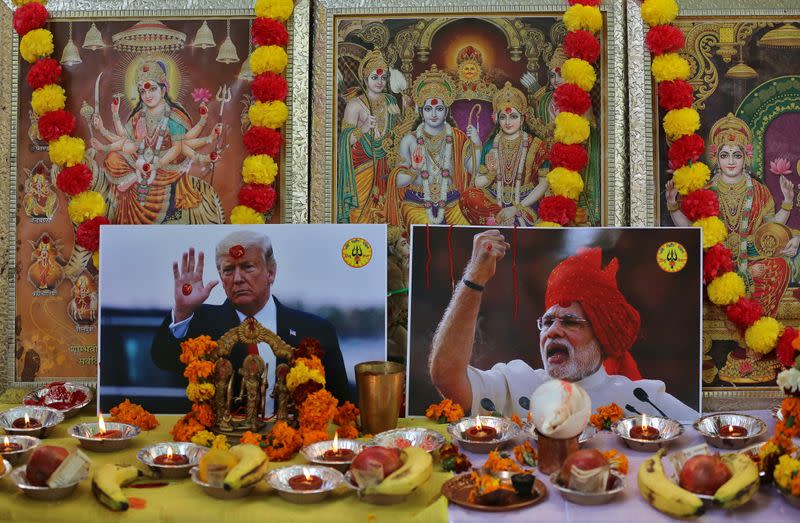 Posters of US President Donald Trump and Indian PM Narendra Modi are placed in front of the images of Hindu deities during a prayer ceremony organised by Hindu Sena to welcome Trump and for the world peace, in Ne