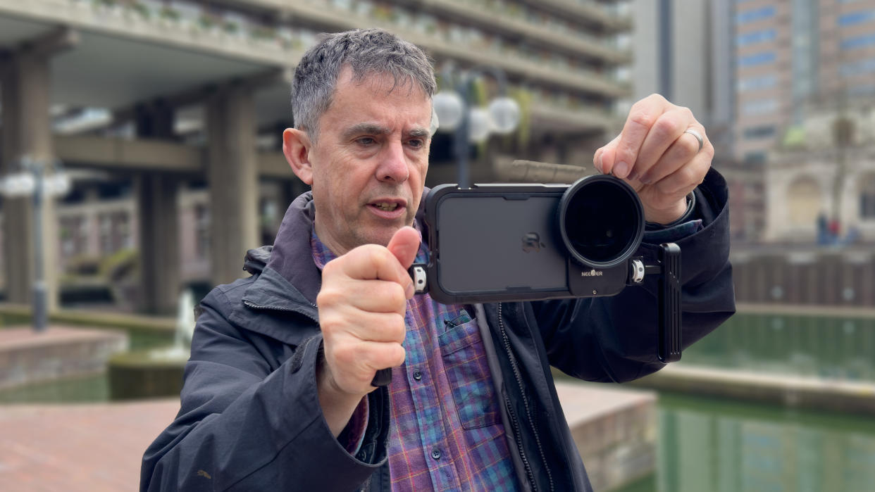  NEEWER PA024K Cage for iPhone 15 Pro Max held in the hands of DCW reviewer George Cairns. 