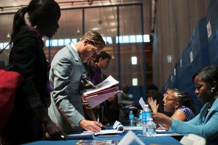 FILE PHOTO: Job seekers speak to recruiters at a job fair sponsored by New York Department of Labor in New York