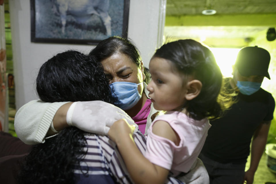 FILE - In this May 25, 2020 file photo, Maria Del Carmen Acero Camacho, center left, embraces one of her nieces as she is reunited with her family after 21 days in the hospital battling COVID-19, in the Iztapalapa borough of Mexico City. Acero returned home weak, but vivacious, recounting to her family the kindness and encouragement of the nurses who cared for her, as well as the devastation of watching fellow patients dying around her. (AP Photo/Rebecca Blackwell, File)