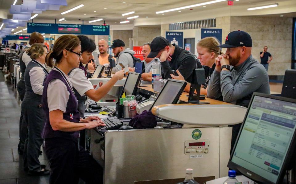 Joe Barker (far right) manages to book a flight to Atlanta at the Palm Beach International Airport Wednesday September 28, 2022. Barker said, "My flight has been canceled 3 or 4 times this morning. I'm heading to California."