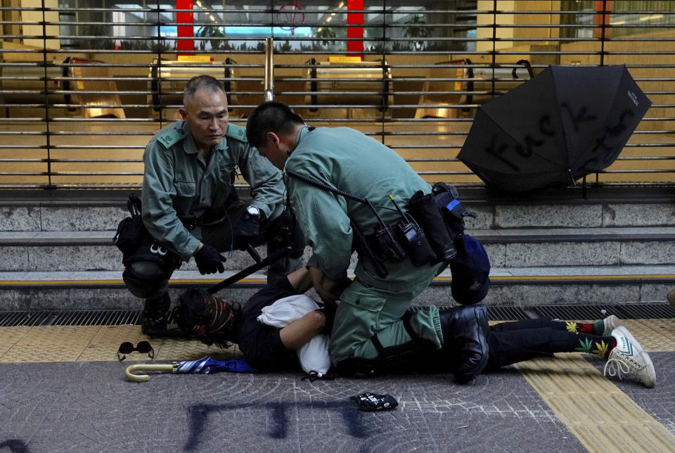 Hong Kong police detain a protester on the streets of Hong Kong on Saturday, Oct. 5, 2019. All subway and train services were suspended, lines formed at the cash machines of shuttered banks, and shops were closed as Hong Kong dusted itself off and then started marching again Saturday after another night of rampaging violence decried as "a very dark day" by the territory's embattled leader. (AP Photo/Vincent Yu)