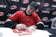 Dave Ayres signs autographs on a shirt with his name and number before an NHL hockey game between the Carolina Hurricanes and the Dallas Stars in Raleigh, N.C. on Tuesday, Feb. 25, 2020. Ayres became a sudden hero to Hurricanes fans when he came into the game as an emergency goaltender in Toronto on Saturday and the Hurricanes won the game. (AP Photo/Chris Seward)