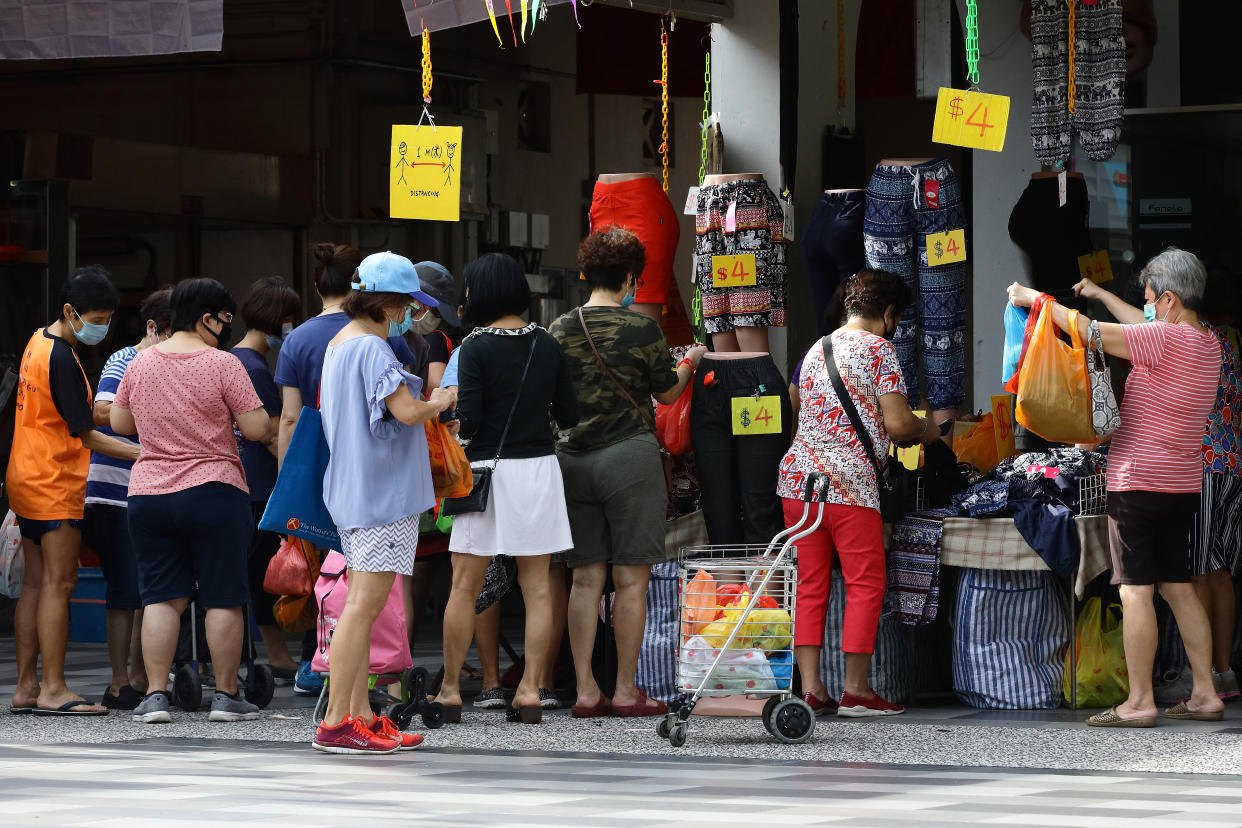 SINGAPORE - JULY 07:  People shop for pants on sale without observing social distancing on July 7, 2020 in Singapore. As of July 7, Singapore reported 157 of coronavirus (COVID-19) infections, seeing an increase in the average number of COVID-19 infections within the community after the country lifted its partial lockdown. The total number of COVID-19 cases in the country stands at 45,140. (Photo by Suhaimi Abdullah/Getty Images)