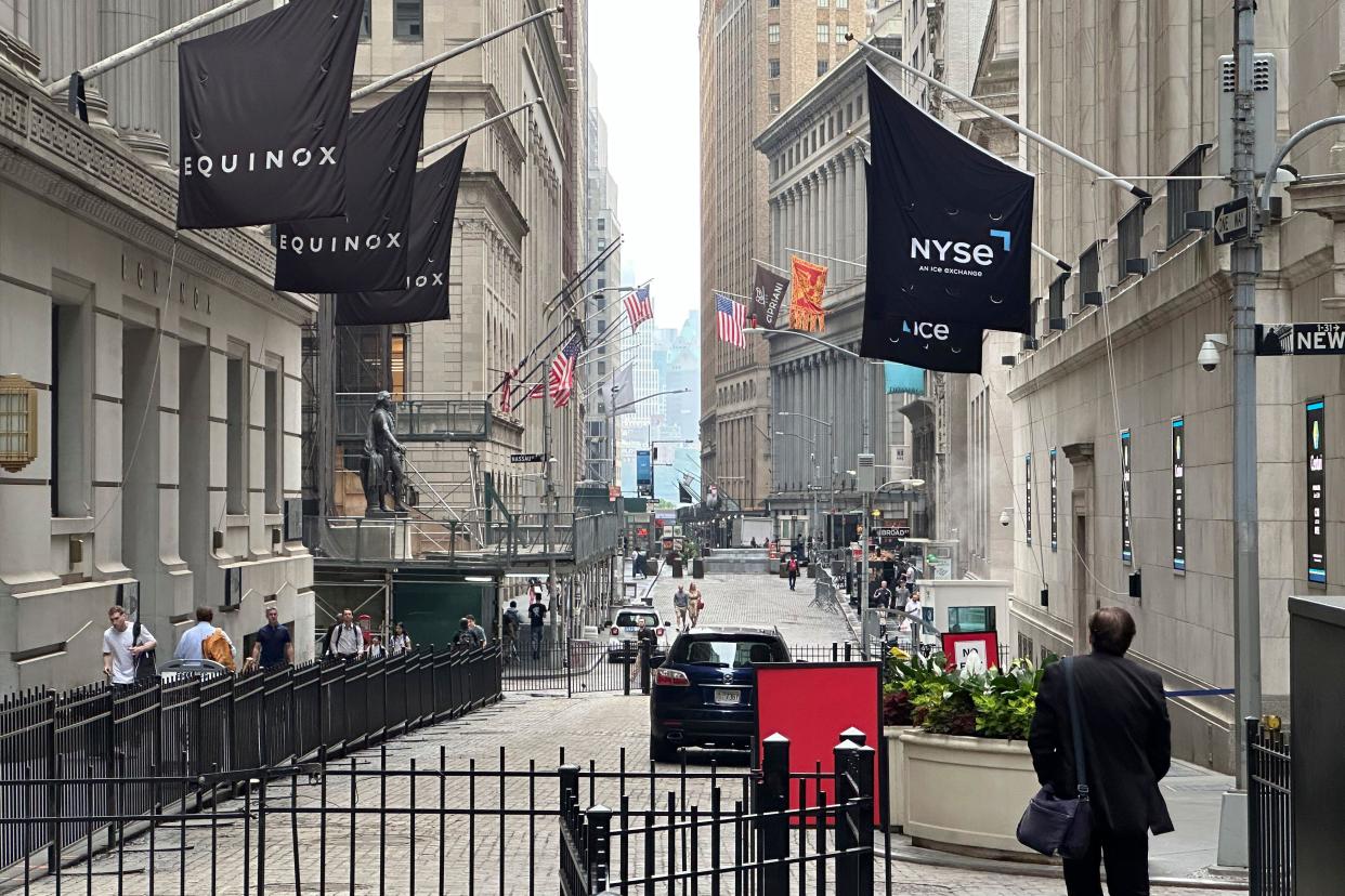 A man walking on Wall Street approaches the New York Stock Exchange