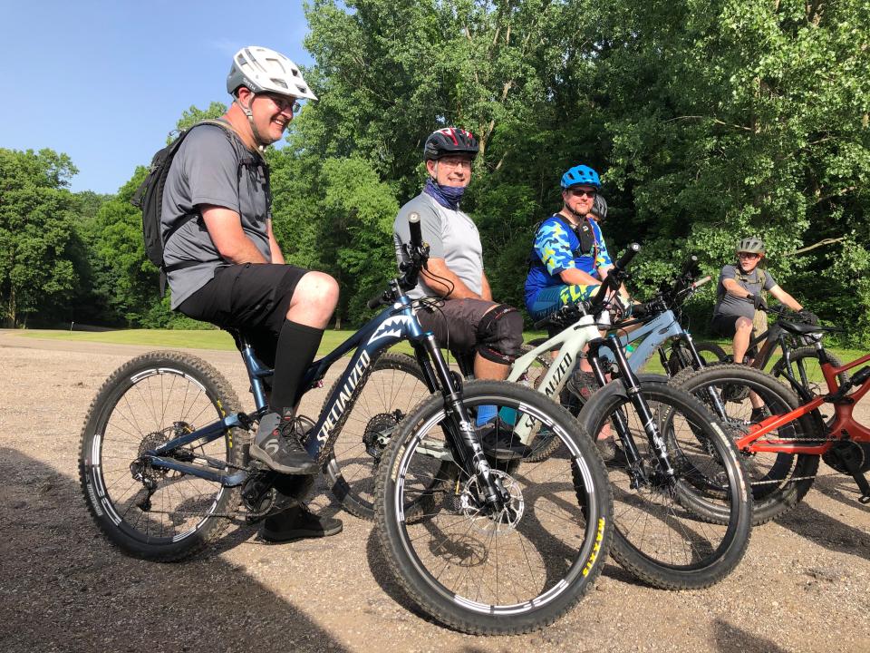 Local e-bike riders gather before they ride the mountain bike trail at Andrews University in Berrien Springs on June 15, 2022.