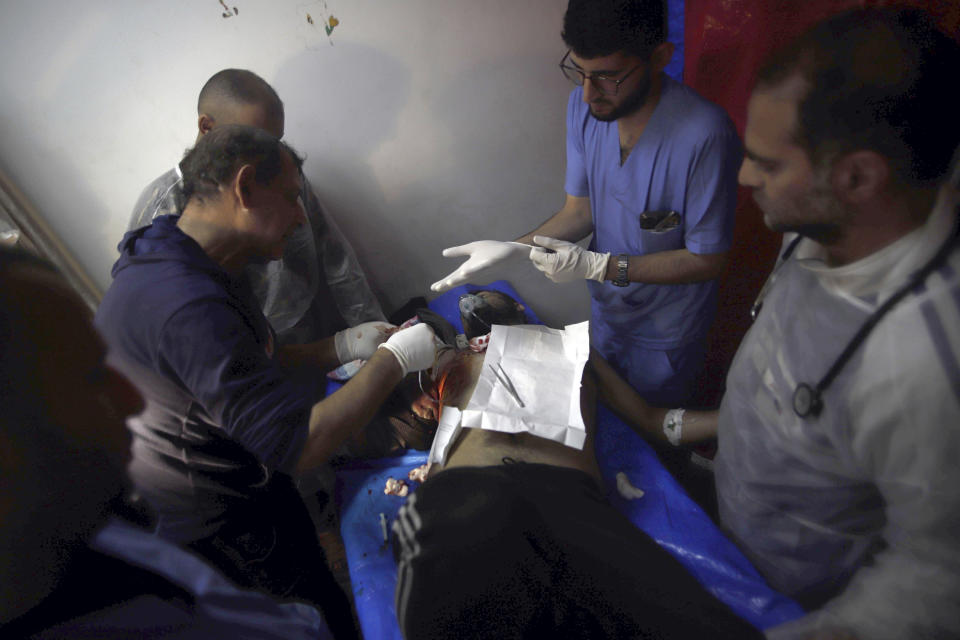 Palestinian medics treat a man wounded in the Israeli bombardment at a building of an UNRWA vocational training center which displaced people use as a shelter in Khan Younis, southern Gaza Strip, Wednesday, Jan. 24, 2024. (AP Photo/Ramez Habboub)