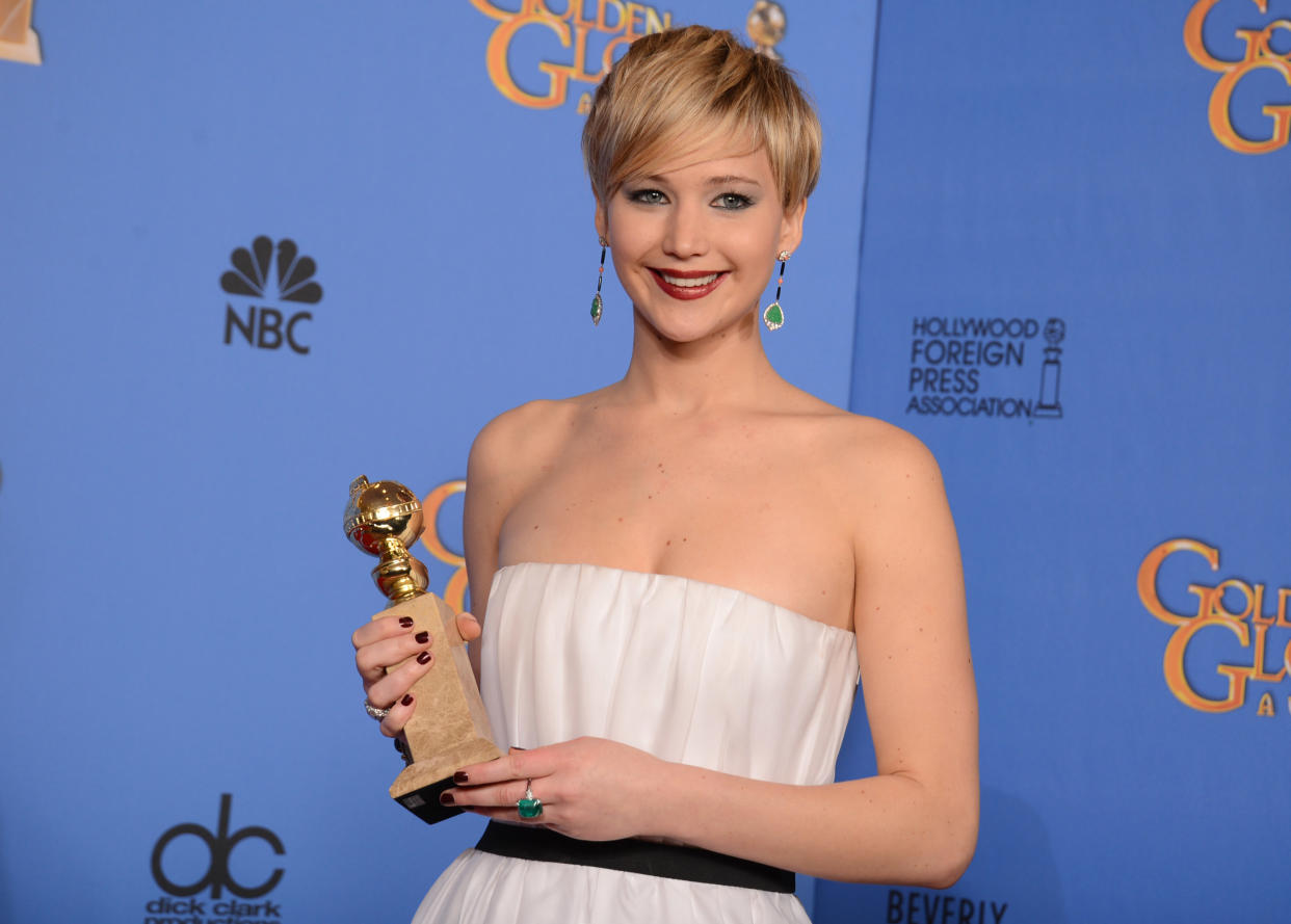 Jennifer Lawrence poses in the press room with the award for best supporting actress for