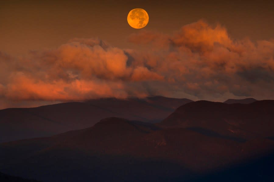 The blue supermoon sets over the White Mountain National Forest at sunrise, Thursday, Aug. 31, 2023, in Carroll County, New Hampshire. The next blue superman won’t occur until 2037. (AP Photo/Robert F. Bukaty)