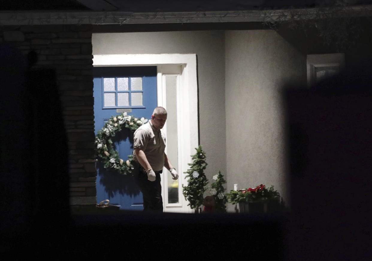 A law enforcement official stands near the front door of the Enoch, Utah, home where eight family members were found dead from gunshot wounds, Wednesday, Jan. 4, 2023. (Ben B. Braun/The Deseret News via AP)