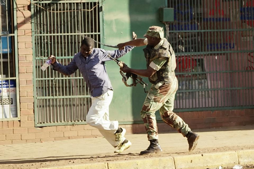 <p>A Zimbabwean soldier beats a man in a street of Harare on August 1, 2018 as protests erupted over alleged fraud in the country’s election. – One man was shot dead, AFP witnessed, after the Zimbabwean army opened fire in central Harare on Wednesday as protests erupted over alleged fraud in the country’s election. President Emmerson Mnangagwa on August 1 called for peace as police fired water cannon and teargas at opposition supporters in Harare over alleged fraud in Zimbabwe’s elections. (Photo: Zinyange Auntony/AFP/Getty Images) </p>