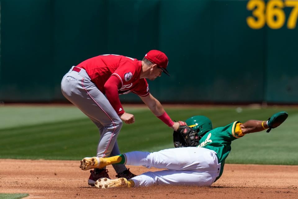 Cincinnati Reds second baseman Kevin Newman, left, tags out Oakland Athletics'  Esteury Ruiz at second on a steal-attempt during the third inning of a baseball game in Oakland, Calif., Sunday, April 30, 2023.