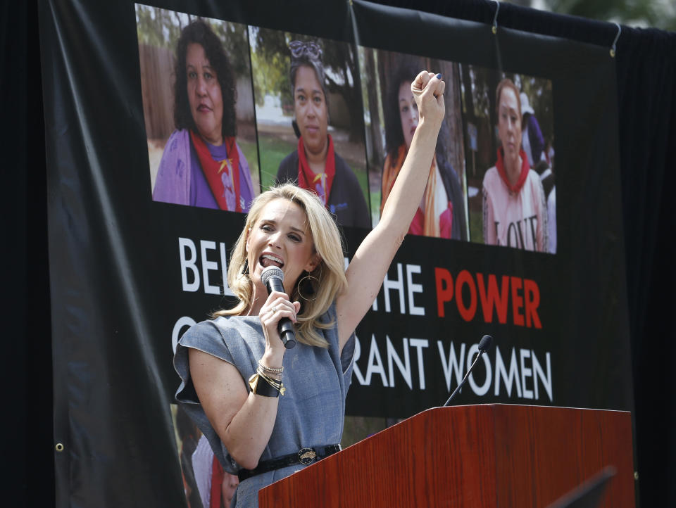 In this photo taken Monday June 24, 2019 first partner Jennifer Siebel Newsom leads a cheer at the graduation ceremony for janitors who received certificates to teach rape and violence prevention to their peers, at the Capitol in Sacramento, Calif. Siebel Newsom has shunned the traditional title of "first lady" and is focusing on women's issues including equal pay and expanding family leave. (AP Photo/Rich Pedroncelli)