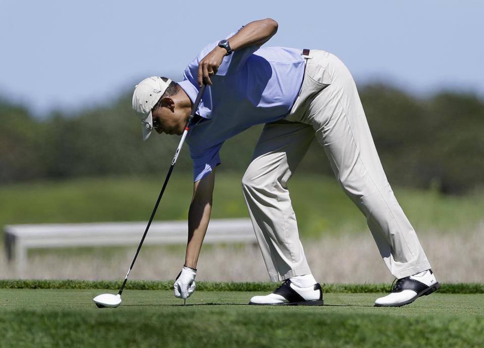 President Barack Obama prepares to tee off while golfing at Vineyard Golf Club in Edgartown, Mass., on the island of Martha's Vineyard Wednesday, Aug. 14, 2013. President Obama and his wife Michelle are vacationing on the island. (AP Photo/Steven Senne)