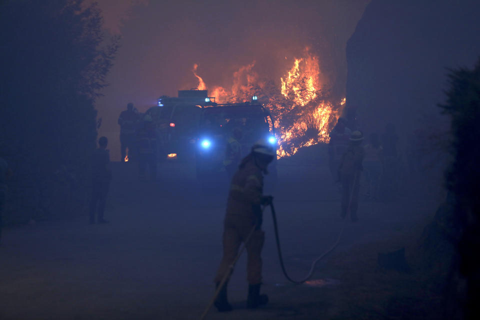 Firefighters battle a wildfire in Gouveia, in the Serra da Estrela mountain range, in Portugal on Thursday, Aug. 18, 2022. Authorities in Portugal said Thursday they had brought under control a wildfire that for almost two weeks raced through pine forests in the Serra da Estrela national park, but later in the day a new fire started and threatened Gouveia. (AP Photo/Joao Henriques)