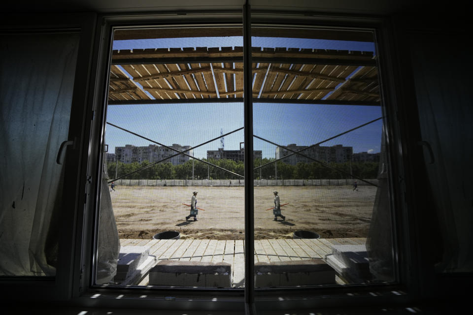 FILE - Damaged and burned buildings are seen from an open window of a new apartment block that is being built with support of the Russia Defense Ministry in Mariupol, in territory under control of the government of the Donetsk People's Republic, in eastern Ukraine, Wednesday, July 13, 2022. This photo was taken during a trip organized by the Russian Ministry of Defense. (AP Photo/File)