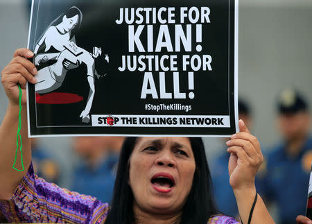 A protester holds a placard and shouts anti-government slogans, seeking justice for 17-year-old high school student Kian delos Santos, who was killed in a recent police raid in an escalation of President Rodrigo Duterte's war on drugs, during a protest in front of the Philippine National Police (PNP) headquarters in Quezon city, Metro Manila, Philippines August 23, 2017. REUTERS/Romeo Ranoco