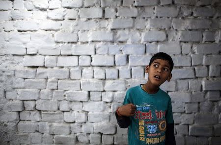 Eight-year-old Abhi, who suffers from mental and physical disabilities, plays outside his house at a slum in Bhopal November 15, 2014. REUTERS/Danish Siddiqui