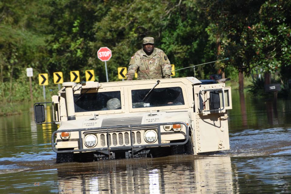 Personnel from the Louisiana National Guard drive through flooded streets in Alexandria, Louisiana, on Saturday.